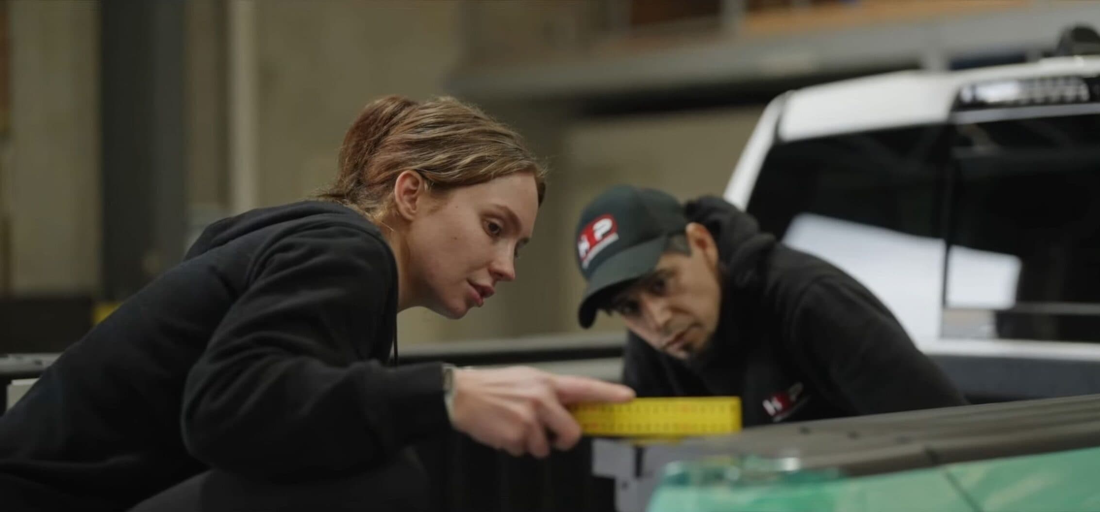 Operating the HSP Roll Mate: hands operating the hard roll-up tonneau cover across the ute tub