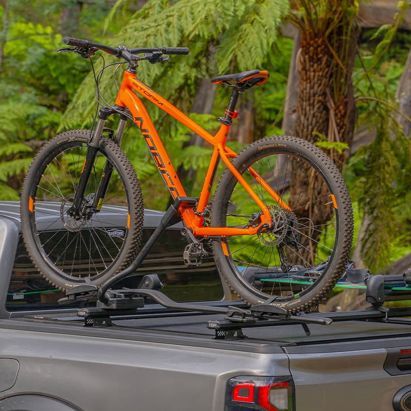Showcasing HSP Load bar with thule & rhino rack accessories to hold a mountain bike & snowboard on the ute tub.
