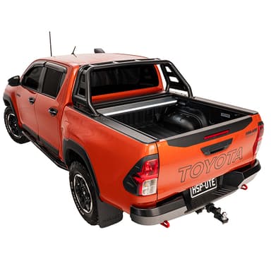 Rear three quarter view of orange Toyota Hilux Rugged X with HSP Roll Top and HSP Roller Cover open showing tub