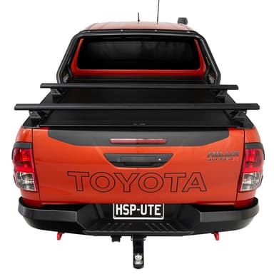 Rear view of orange Toyota Hilux Rugged X with HSP Load Bars fitted over closed HSP Roller Cover