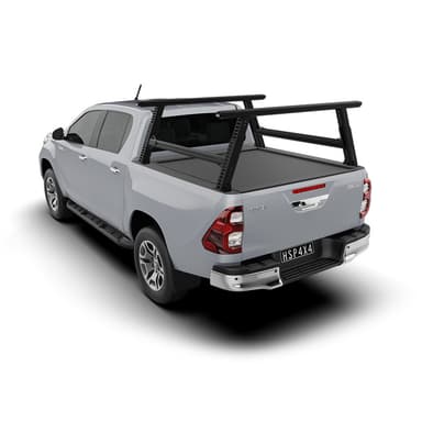 HSP Load Rack Pro fitted to white Toyota Hilux dual cab, angled rear view showing cross bars and a closed HSP Roller Cover