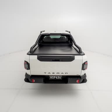 Straight rear view of a Kia Tasman fitted with the HSP Roll R electric roller cover, showing the closed aluminium roller shutter and integrated rear handle above the tailgate.