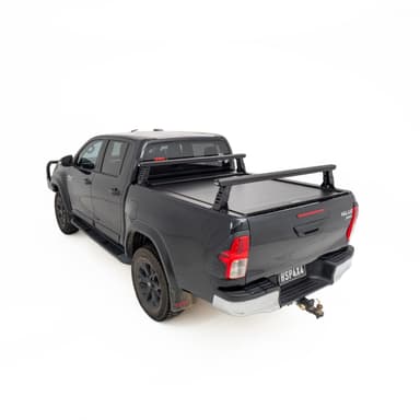 HSP Load Rack JNR fitted to black Toyota Hilux dual cab, rear three quarter view showing compact ladder rack over open tub fitted with a HSP Roller Cover