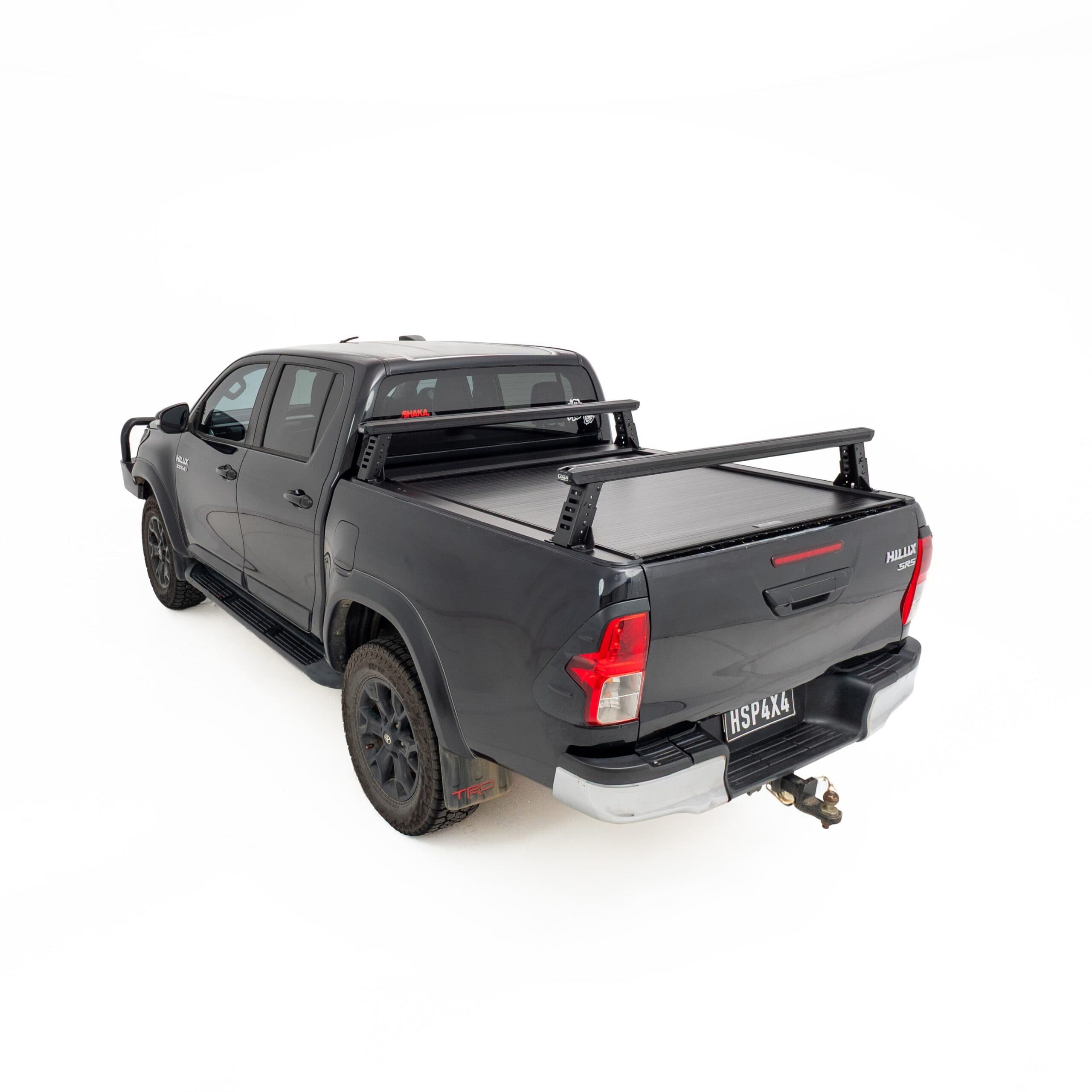 HSP Load Rack JNR fitted to black Toyota Hilux dual cab, rear three quarter view showing compact ladder rack over open tub fitted with a HSP Roller Cover