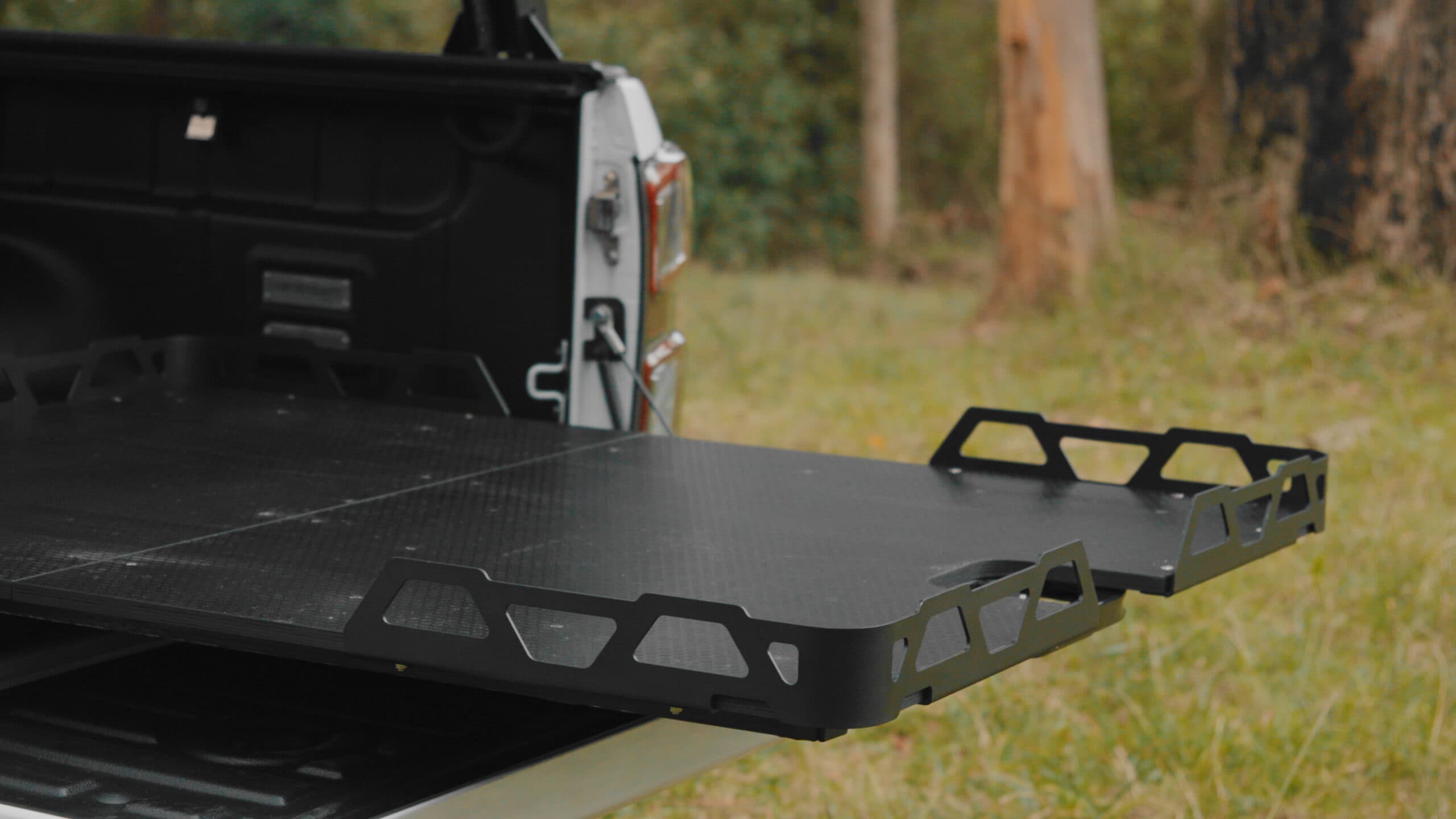 Universal Load Slide: Australian-made HSP dual cab ute tray slide extended from a white ute tub outdoors
